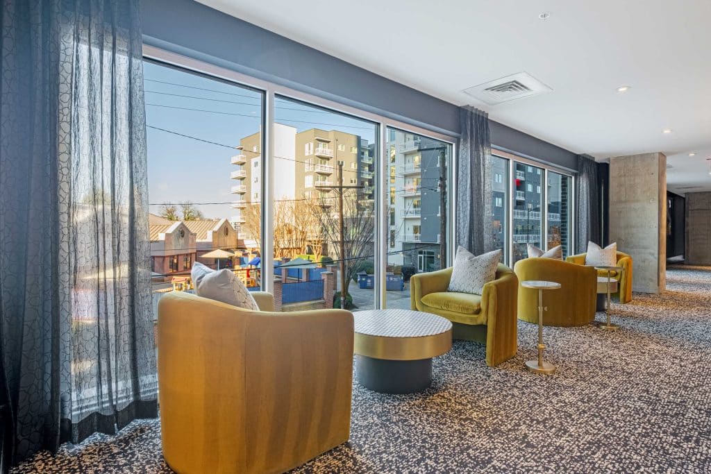Furnished clubroom with desks and chairs with floor to ceiling windows